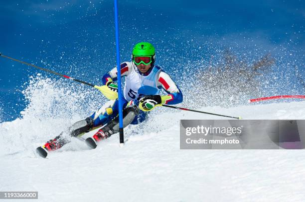 shot of professional alpine skier racing slalom - slalom skiing stock-fotos und bilder