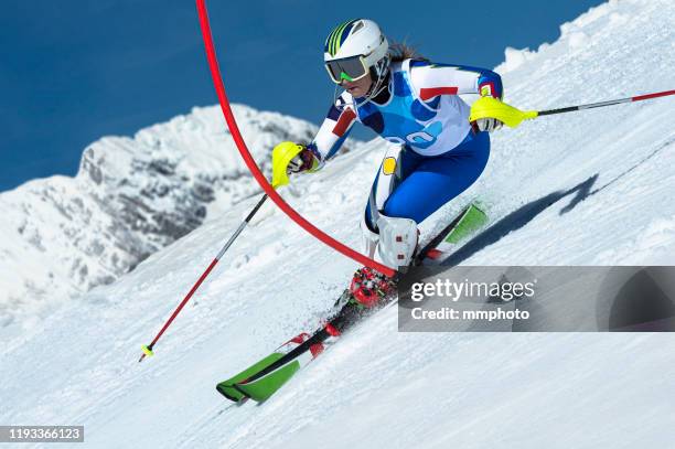 adult female alpine skier racing slalom - alpine skiing stock-fotos und bilder