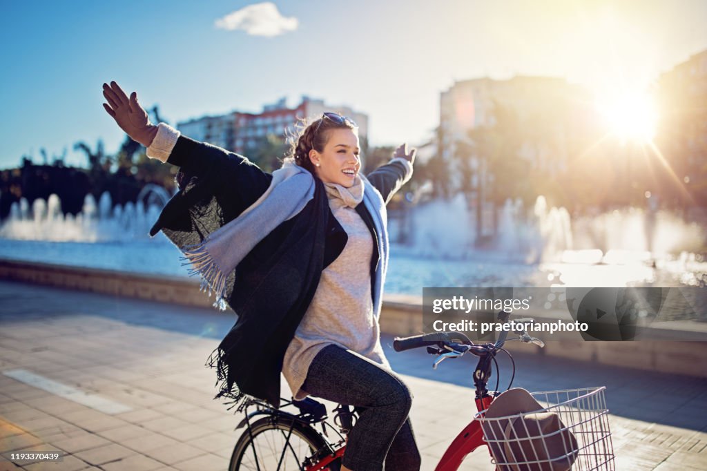 La jeune fille monte un vélo sans mains dans le stationnement