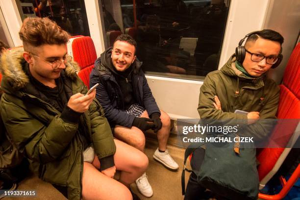 Passengers not wearing pants travel on the subway during the "No Pants Subway Ride" on January 12, 2020 in Prague. - The No Pants Subway Ride is an...