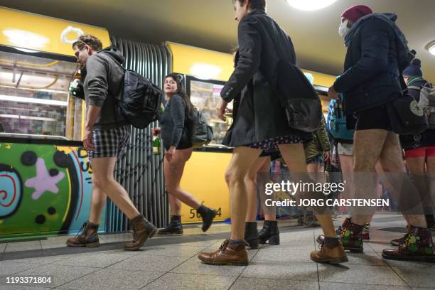 Passengers not wearing pants wait to board a train at the subway during the "No Pants Subway Ride" on January 12, 2020 in Berlin. - The No Pants...