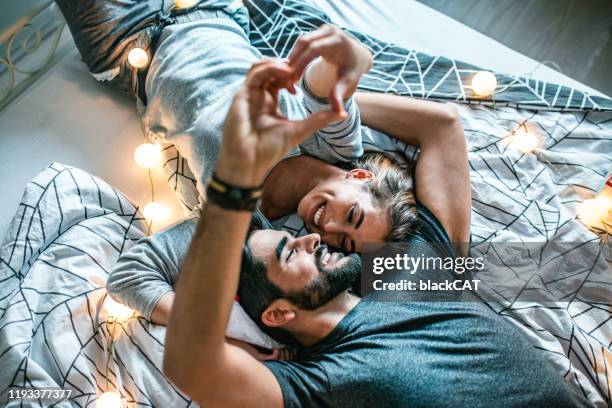 romantischejunges paar im bett - love at first sight stock-fotos und bilder