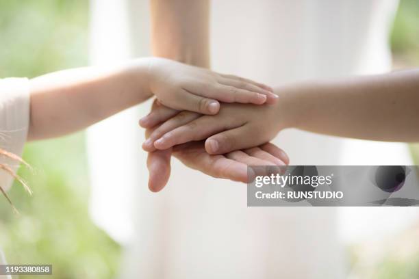 family stacking hands outdoors - hand stack stock pictures, royalty-free photos & images