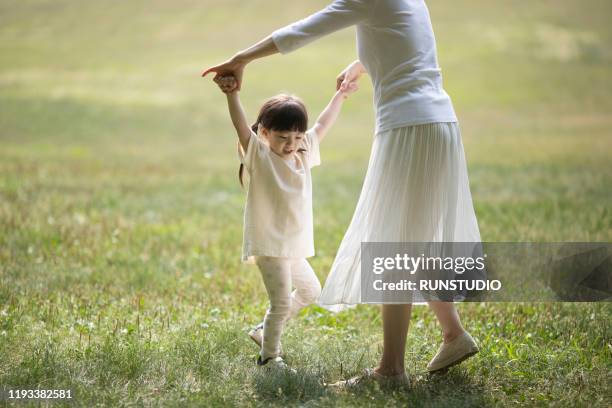 mother and girl dancing joyfully in park - children dancing outside stockfoto's en -beelden