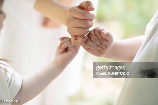 mother and children pinky swearing - pinky promise stock pictures, royalty-free photos & images