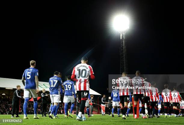 The two sides make their way out during the Sky Bet Championship match between Brentford and Cardiff City at Griffin Park on December 11, 2019 in...