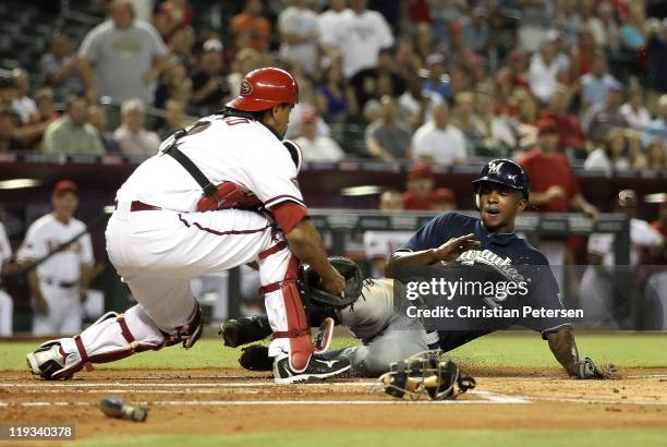 Nyjer Morgan of the Milwaukee Brewers is tagged out by catcher Henry Blanco of the Arizona Diamondbacks as he attempts to score during the first...