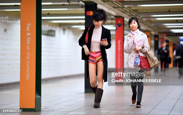 Participants in the 19th Annual "No Pants Subway Ride" wait to board a train in the subway on January 12, 2020 in New York. - The "No Pants Subway...