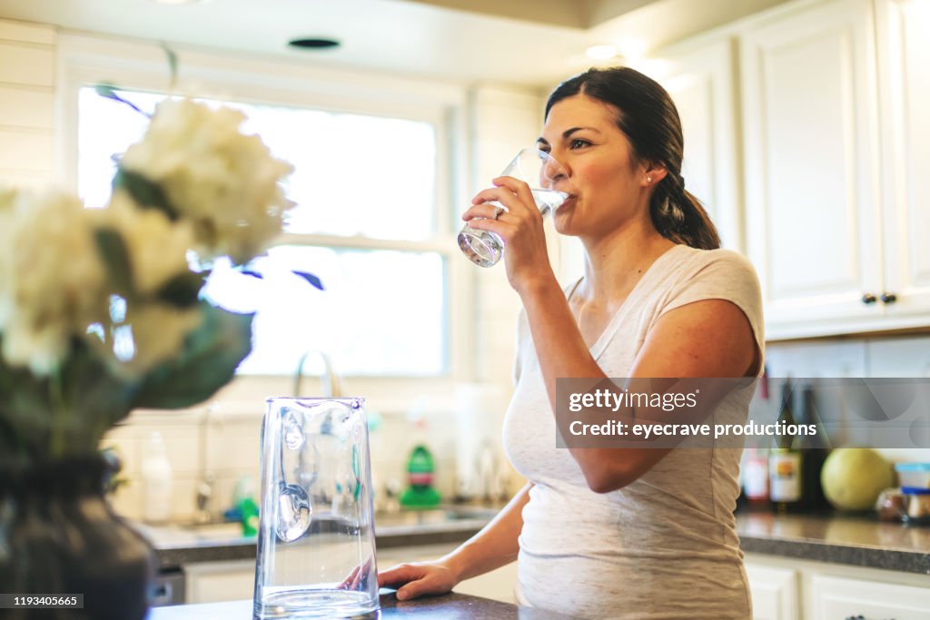 Beautiful Young Adult Millennial Female using water in residential home