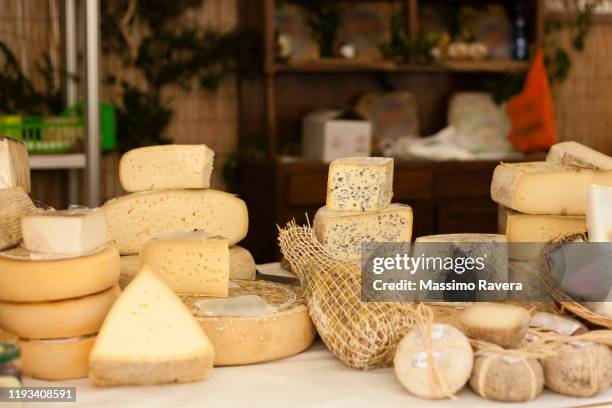 cheese exposed on a market stall - hartkäse stock-fotos und bilder