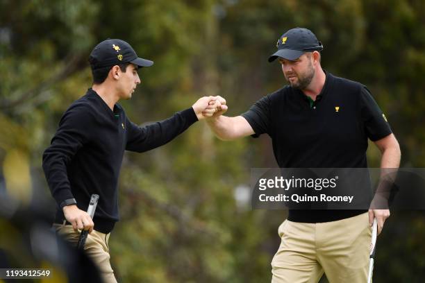 Marc Leishman of Australia and the International team celebrates with Joaquin Niemann of Chile and the International team on the 12th green during...