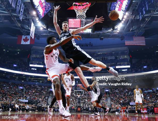 Anunoby of the Toronto Raptors passes the ball as Jakob Poeltl of the San Antonio Spurs defends during the first half of an NBA game at Scotiabank...