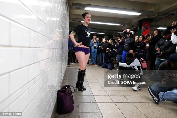 Woman with no pants poses for a photo in the subway. As a part of a comedic stunt in 2002 seven riders took their first "No Pants Subway Ride" in New...