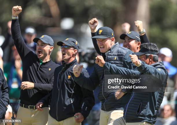 Ernie Els of South Africa the International Team captain celebrates with Trevor Immelman, Mike Weir, Byeong Hun An and K.J.Choi as another putt goes...