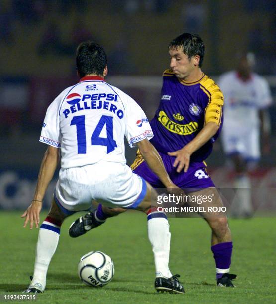 Chilean player of Deportes Concepcion, Patricio Almendra fights for the ball with Nacional's Richard Pellejero 11 April 2001 in Montevideo. El...