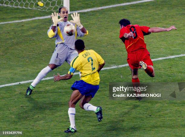 Brazilian goalkeeper Marcos saves a header from Belgian midfielder Bart Goor as Brazilian defender cafu looks on during the second round match...