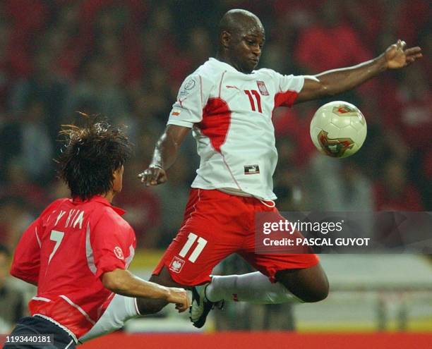 Poland's Nigerian-born forward Emmanuel Olisadebe vies for the ball with South Korea's Kim Tae Young , 04 June 2002 at the Busan Asiad Main Stadium...