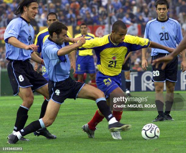 Colombian Arnulfo Valentierra fights for the ball with Uruguayan Montero Castillo and Gonzalo de los Santos as Uruguayan Alvaro Recoba looks on...