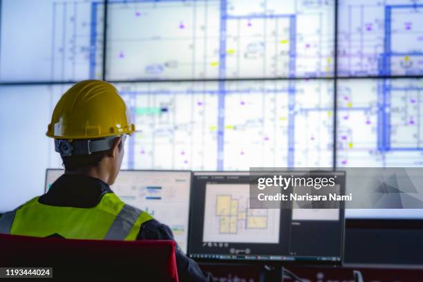 industrial engineering works in front of monitoring screen in the control centre. technology and ai concept. - 管制室 ストックフォトと画像