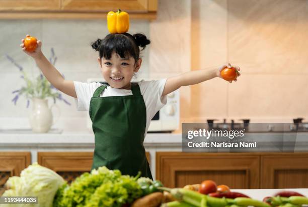 asian kid in the kitchen at home. kid enjoy cooking the healthy food with variety of vegetable. - funny vegetable stock pictures, royalty-free photos & images