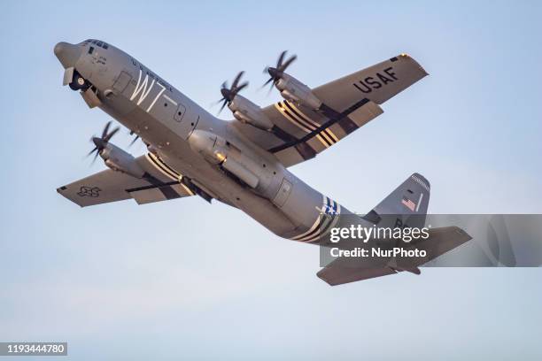 An Iconic C-130 military transport turboprop aircraft during the takeoff phase. The American plane, a Lockheed Martin C-130J-30 Super Hercules of the...