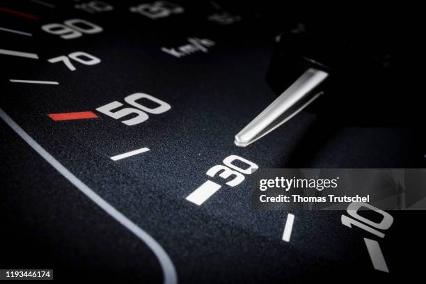 Symbolic photo on the subject of speed limit 30 km / h. A speedometer needle can be seen on a speedometer next to the display for 30 kilometers per...