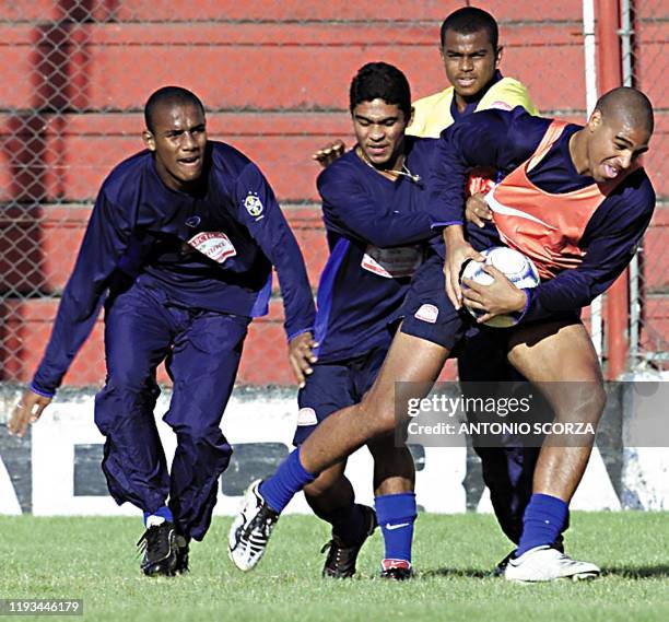 Adriano carries the ball with Anderson Silva and Thiago Santos as Maicon looks on, 30 June 2001 during practice in preparation for an Under-20 World...