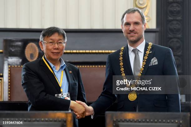 Mayor of Prague Zdenek Hrib and the mayor of Taipei Ko Wen-je shake hands on January 13, 2020 at the Old Town Hall in Prague. - Zdenek Hrib signed an...