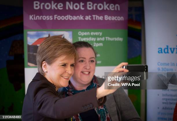 First Minister Nicola Sturgeon takes a selfie with secretary Annie McCormack during a visit to the Broke not Broken food bank on January 13, 2020 in...