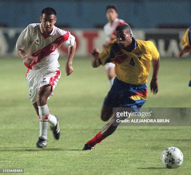 El jugador peruano Gregorio Bernales y su contrincante ecuatoriano Ulises De La Cruz intentan alcanzar el balon en el Estadio Nacional de Lima, 10 de...