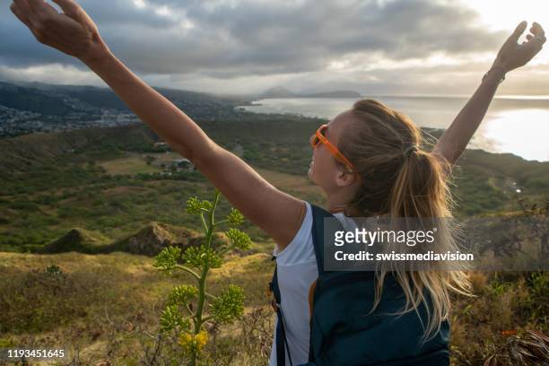 young woman on mountain top arms outstretched, honolulu, hawaii, usa - diamond head stock pictures, royalty-free photos & images