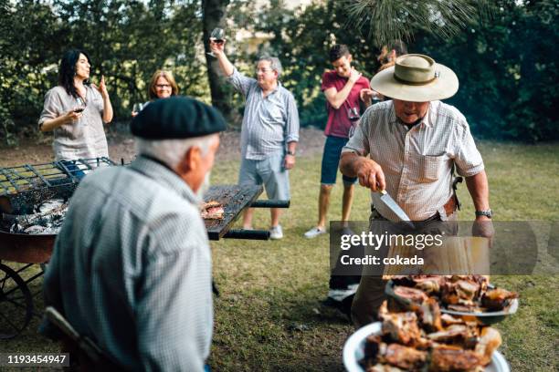 argentijnse familie genieten van barbecue buitenshuis - argentijnse-cultuur stockfoto's en -beelden