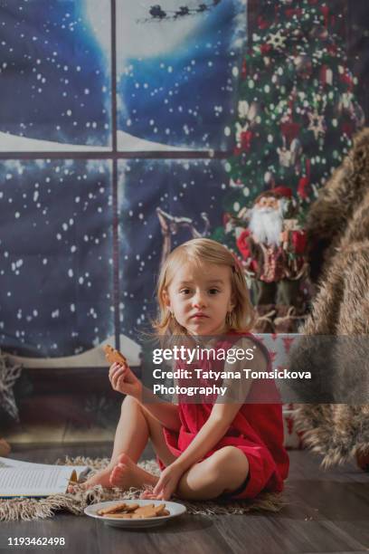 beautiful toddler girl, opening presents on christmas night - tiny beautiful things opening night celebration stock pictures, royalty-free photos & images