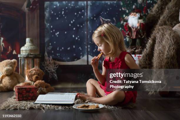 beautiful toddler girl, opening presents on christmas night - tiny beautiful things opening night celebration stock pictures, royalty-free photos & images