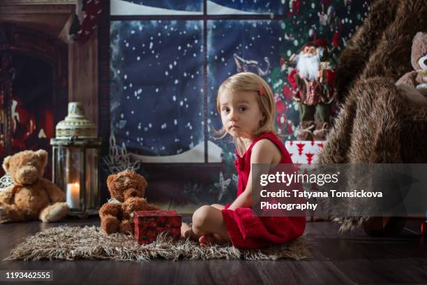 beautiful toddler girl, opening presents on christmas night - tiny beautiful things opening night celebration stock pictures, royalty-free photos & images