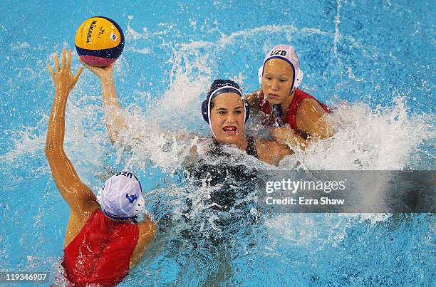 Katrina Monton of Canada looks to pass the ball against Eseniya Ivanova and Evgeniya Ivanova of Uzbekistan during their Women's Water Polo first...