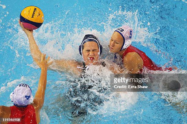 Katrina Monton of Canada looks to pass the ball against Eseniya Ivanova and Evgeniya Ivanova of Uzbekistan during their Women's Water Polo first...