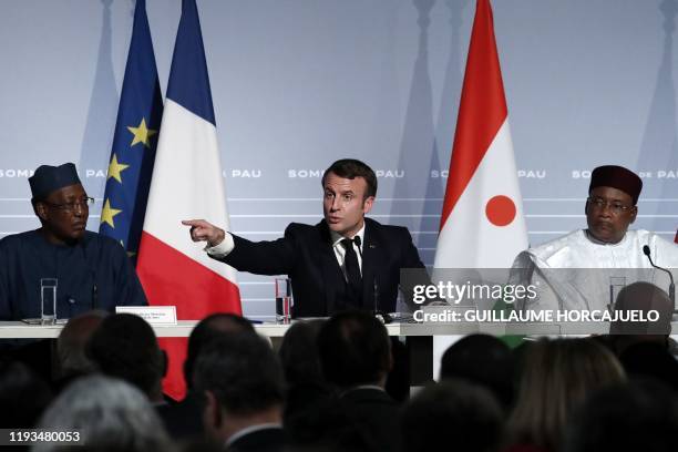 French President Emmanuel Macron flanked by Niger's President Mahamadou Issoufou and Chad's President Idriss Deby speaks during a press conference as...