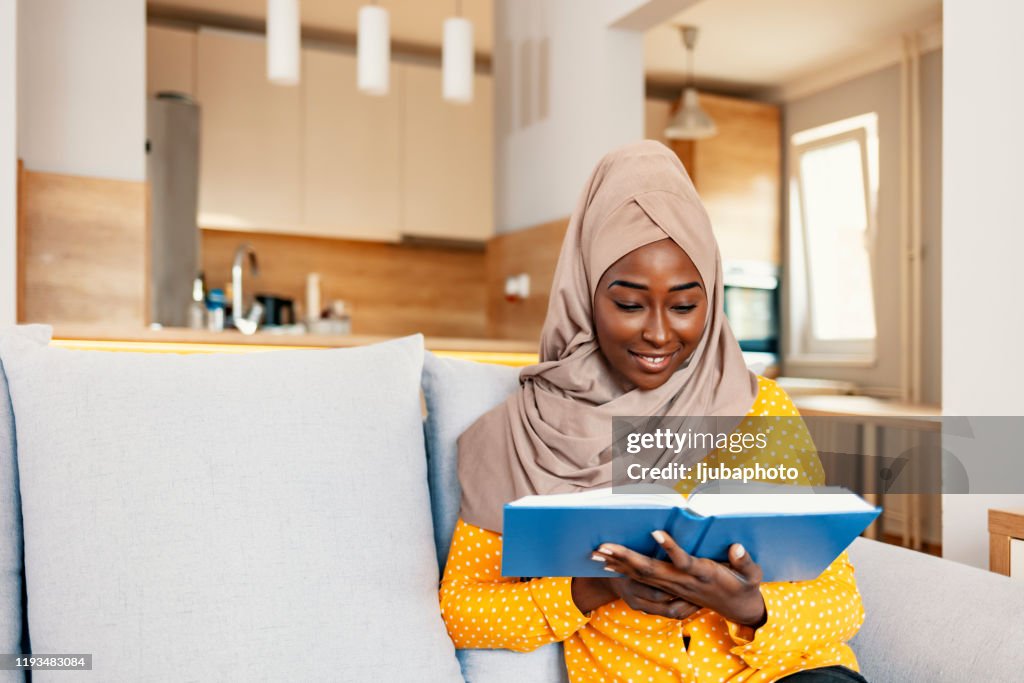 Joven musulmana relajándose y disfrutando de su libro