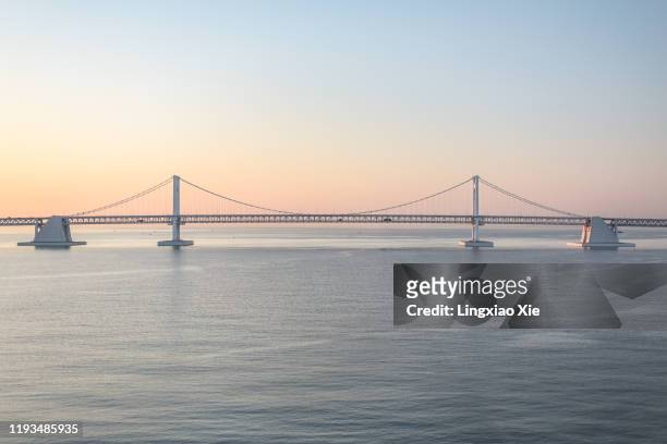 scenic dawn view of gwangan bridge or diamond bridge across blue ocean, busan, south korea - busan stock pictures, royalty-free photos & images