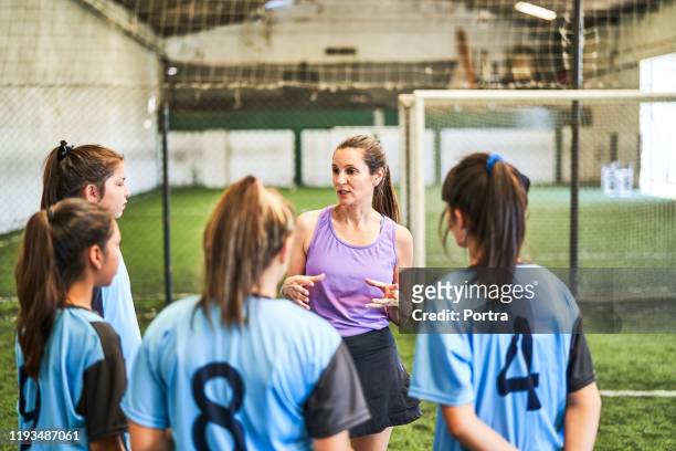 trainer diskutiert mit fußballerischen spielern über spielplan - talent team coaching stock-fotos und bilder