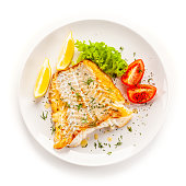 Fried cod fillet and vegetables on white background