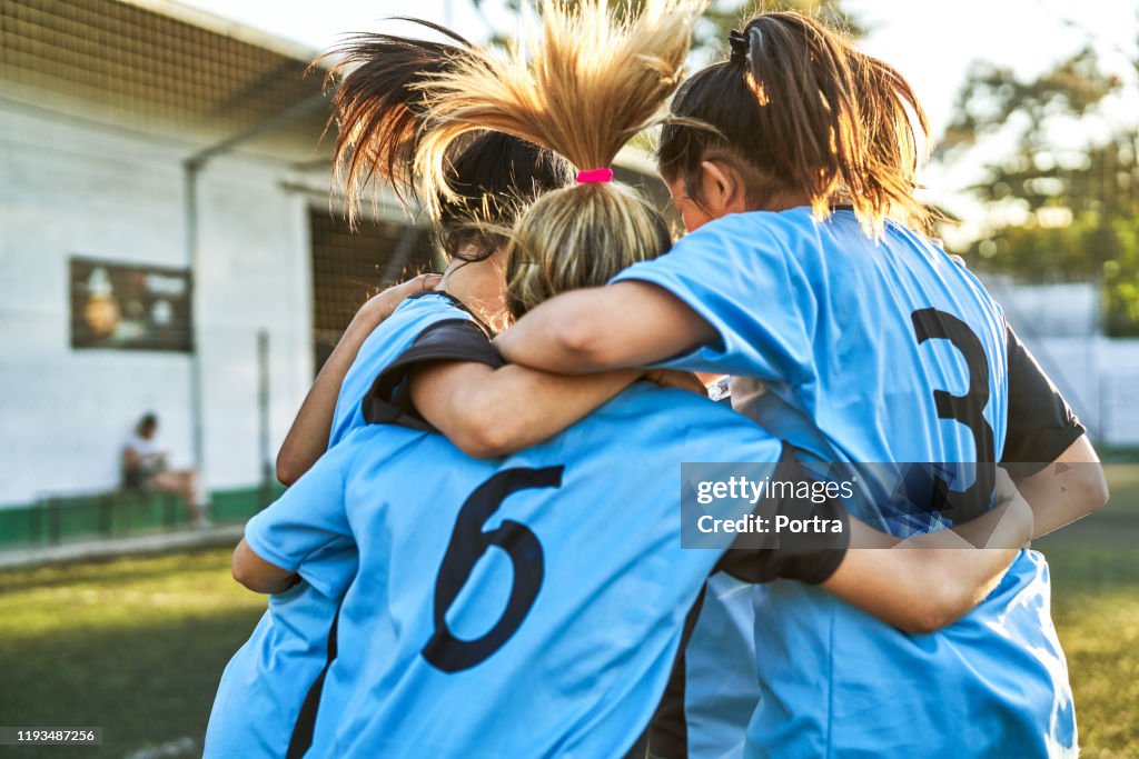 Soccer girls huddling after winning match
