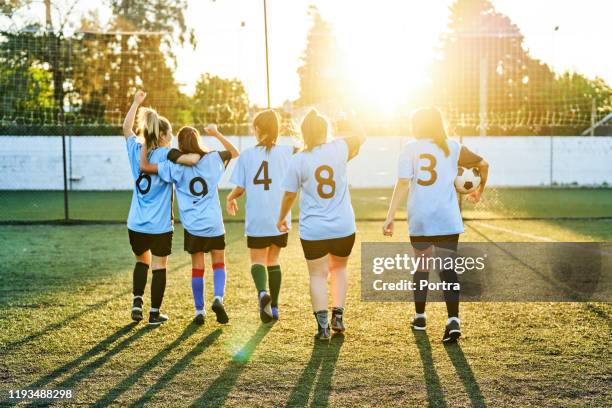 soccer girls celebrating success on sports field - blue shirt back stock pictures, royalty-free photos & images