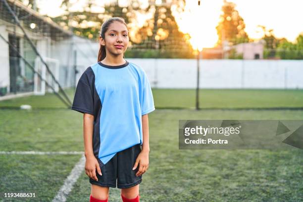 スポーツフィールドに立っている自信のあるサッカーの女の子 - ジャージ ストックフォトと画像