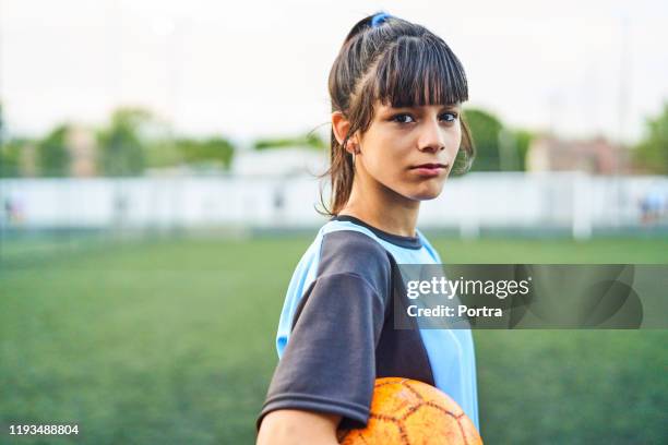 porträt von selbstbewussten fußball-mädchen mit ball - headshots soccer stock-fotos und bilder