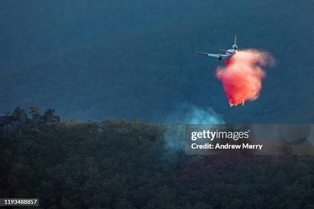 firefighting jet aircraft flying low in mountain valley at dusk, blue mountains, australia - australia bushfire stock pictures, royalty-free photos & images