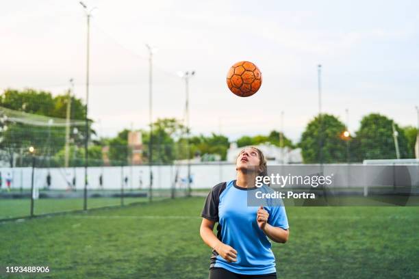 スポーツフィールド上のサッカーの女の子のヘディングボール - ヘディングをする ストックフォトと画像