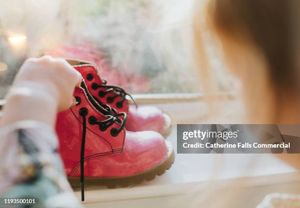 child looking at pink boots - choosing shoes stock pictures, royalty-free photos & images