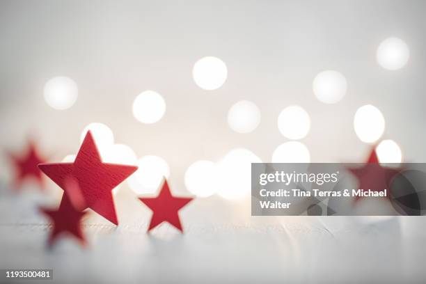 christmas background with red stars with fairy lights. copy space. christmas mood. - kerstroos stockfoto's en -beelden